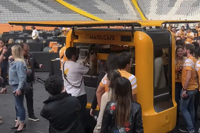 Unidade Smart Moov amarela de café atendendo fila em um evento